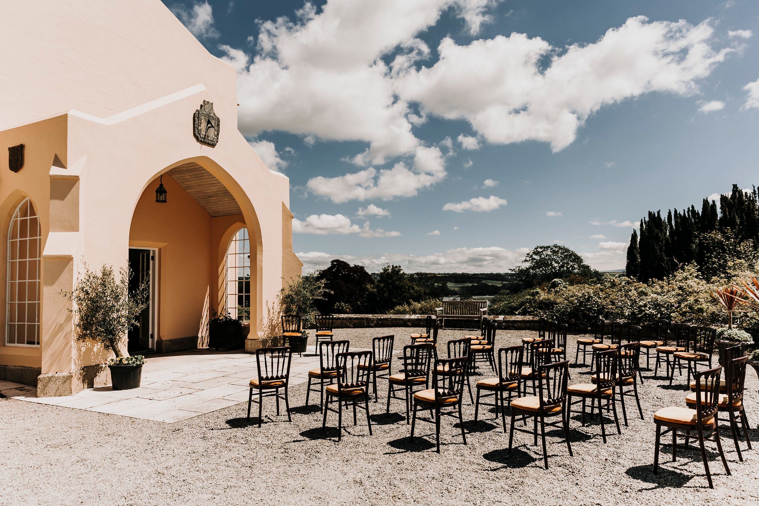 The orangery terrace set for a ceremony, countryside beyond