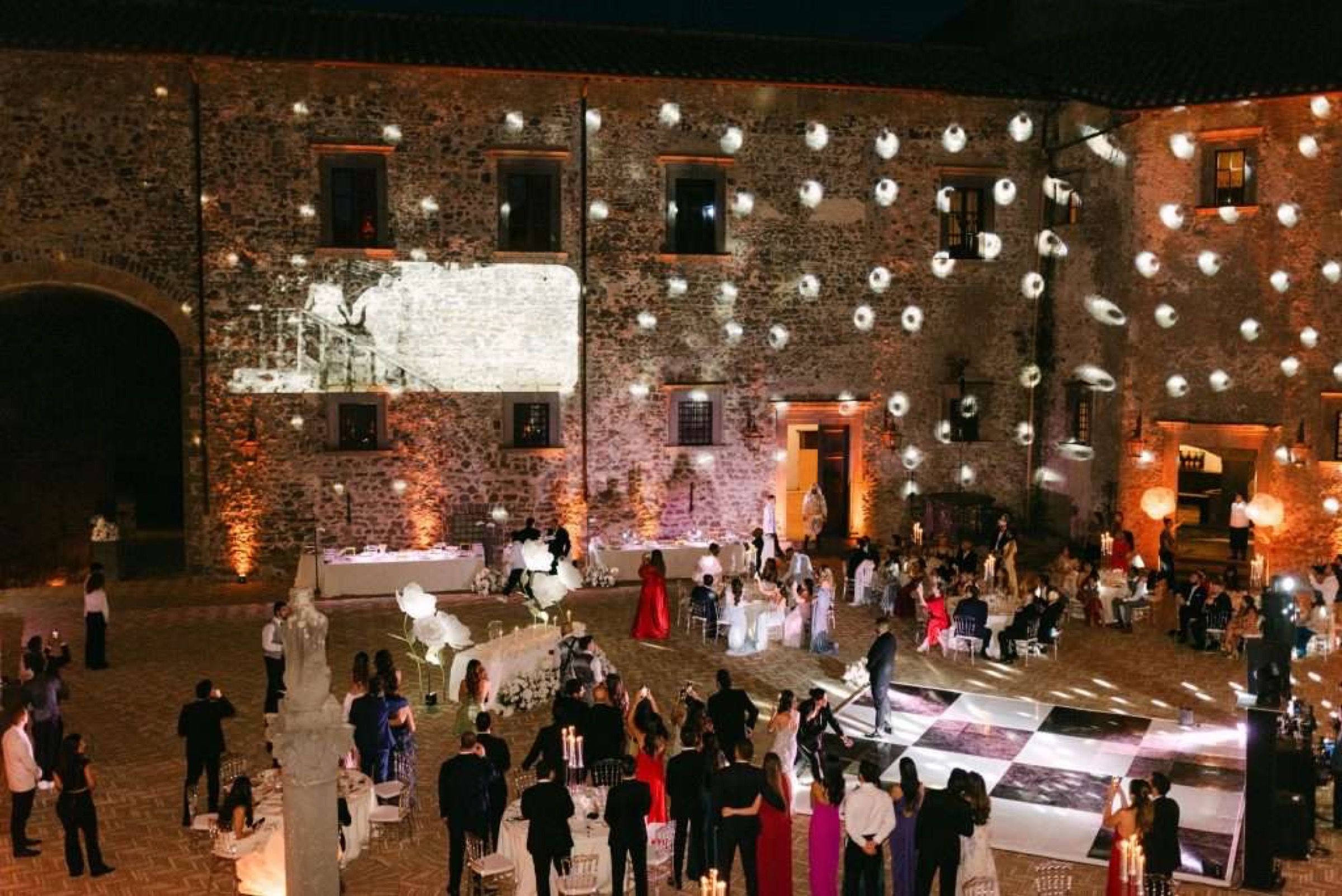 Festoon lights at dusk, a castle wedding