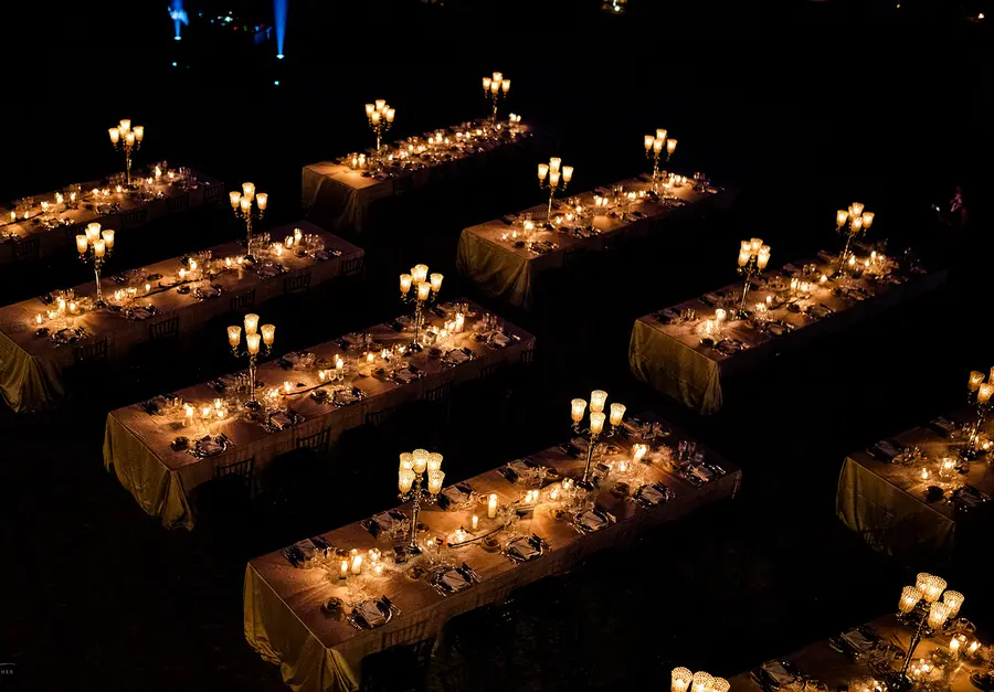 Aerial of the candlelit outdoor reception on the estate lawns at night