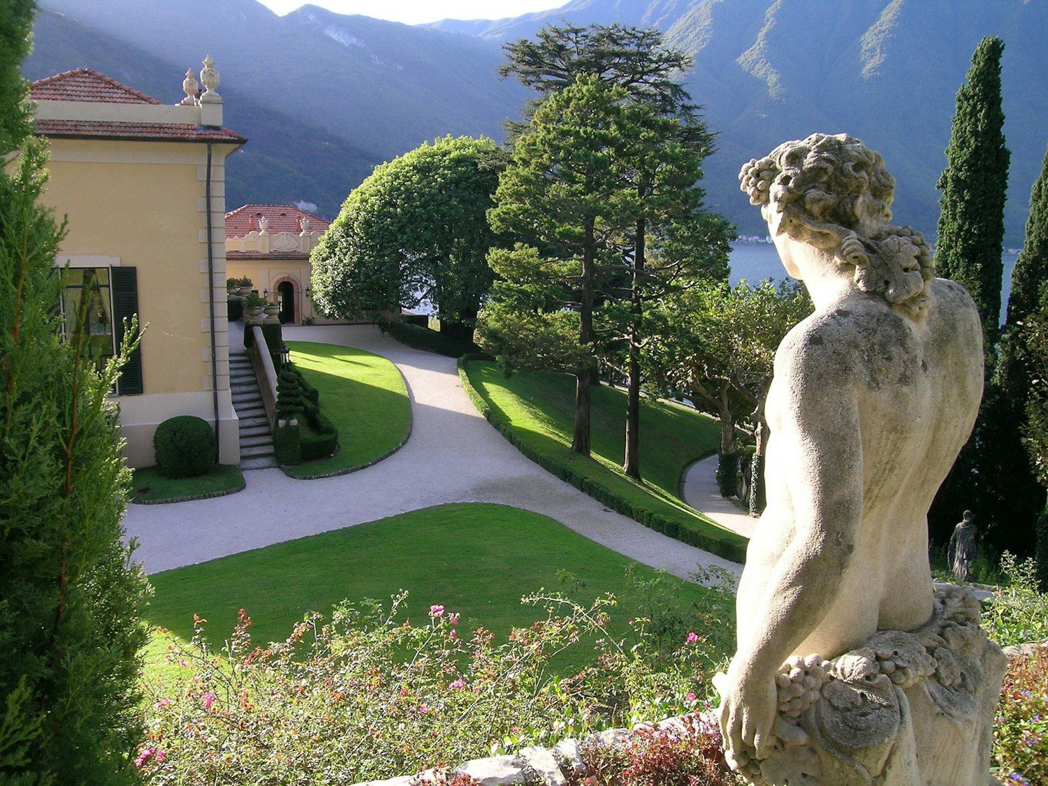 The manicured gardens, a statue and the loggia building above Lake Como, Villa del Balbianello