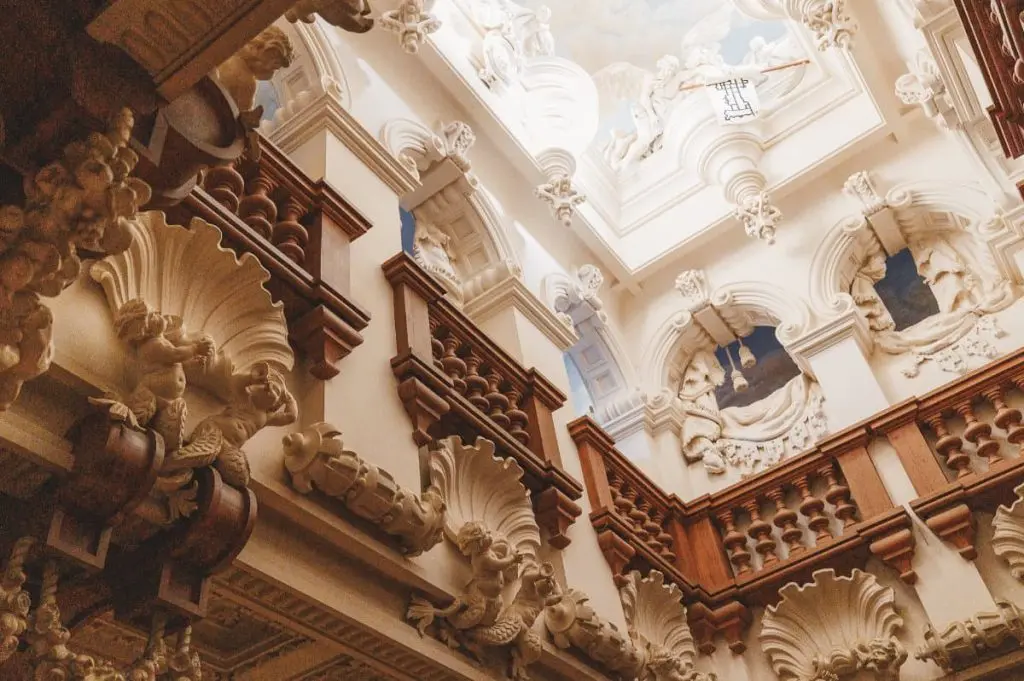 The carved Cedar Staircase rising through Baroque woodwork