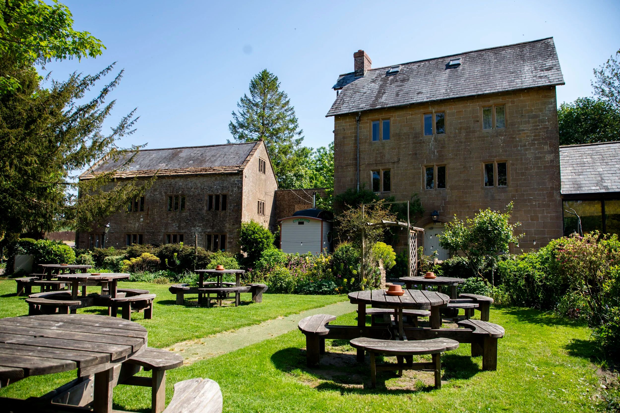 The mill buildings and garden with picnic tables