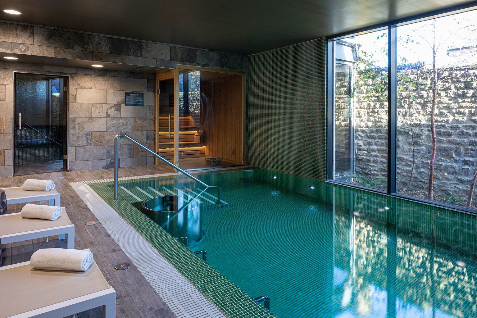 The spa's hydrotherapy pool and sauna, glazed to the greenery outside