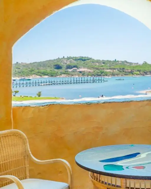 A sea view through a whitewashed arch at Hotel Cala di Volpe