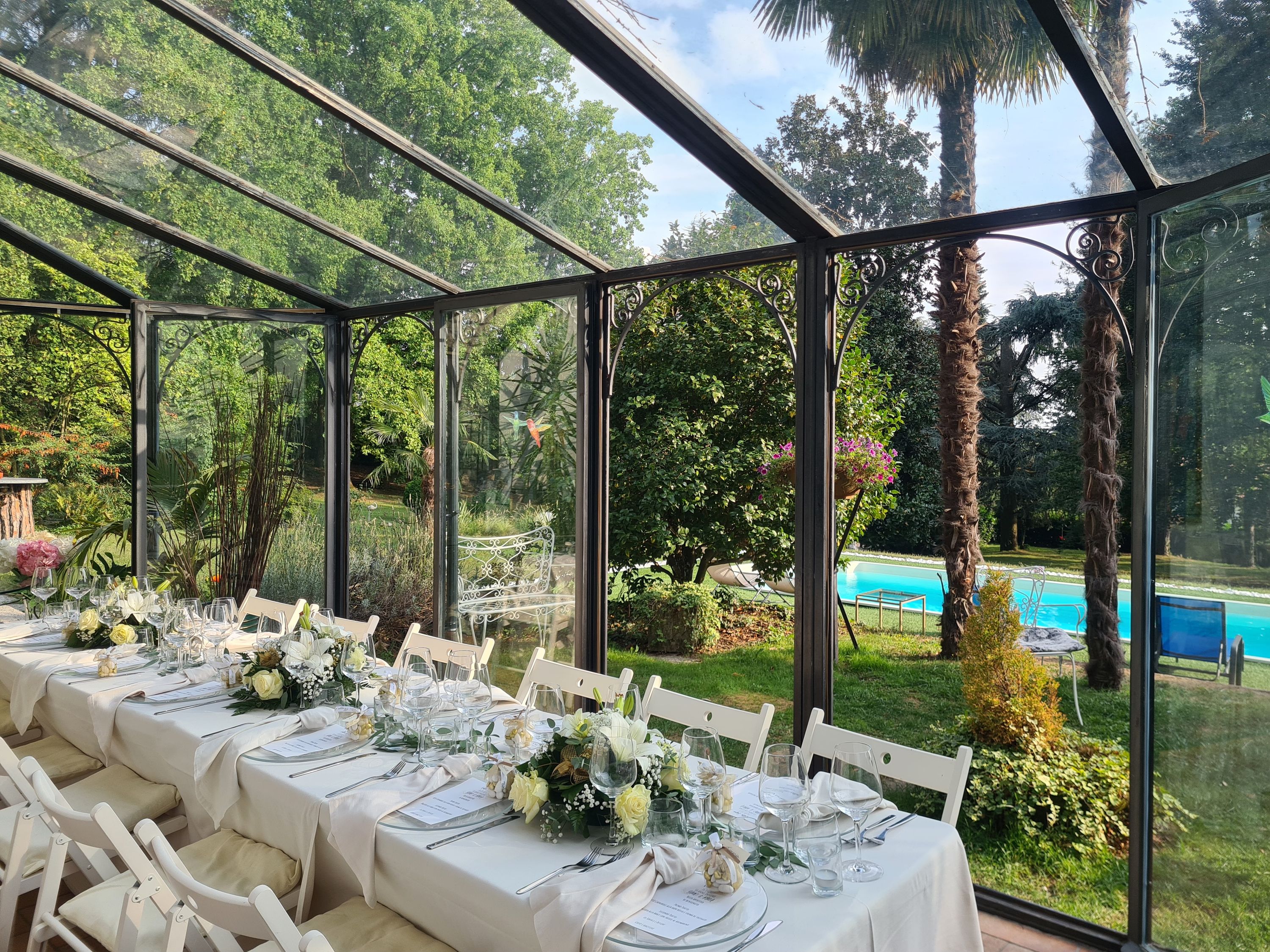 A long banquet table in a glass conservatory
