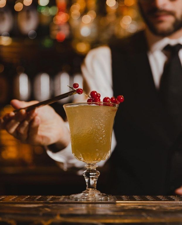 A bartender crafting a garnished cocktail in the Punch Room
