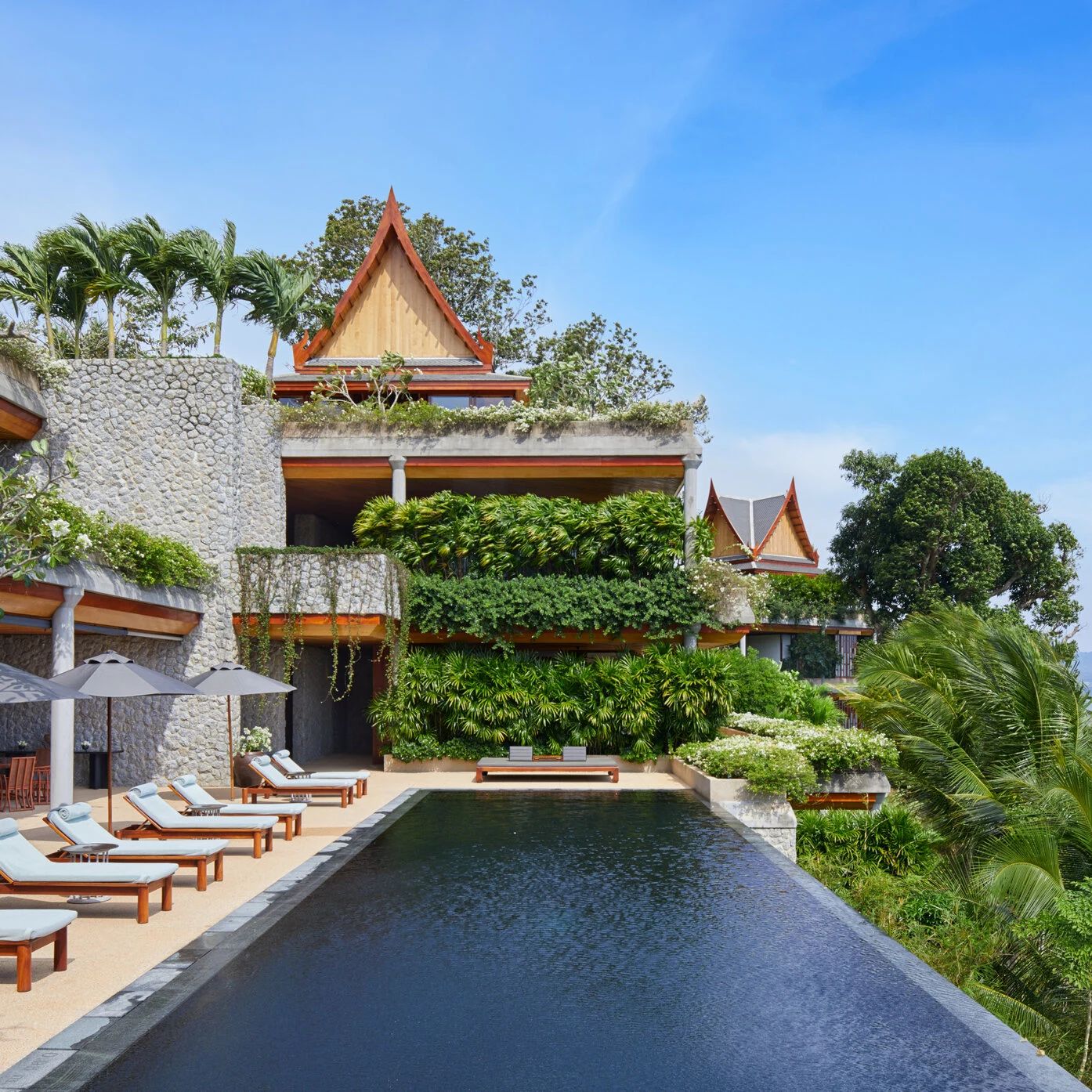 A villa's private pool at Amanpuri, stone walls and a Thai pitched roof above
